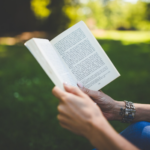 Person reading book outside to introduce the subtopic, "Enhance Reading Comprehension"